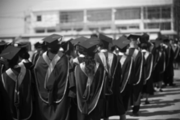 Los graduados están caminando en fila para obtener su título, monótono —  Fotos de Stock