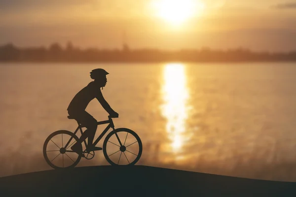 La silueta de un hombre en moto de montaña, puesta de sol — Foto de Stock