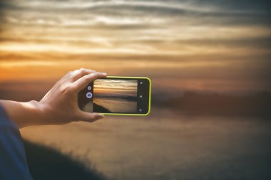 Yetişkin adam smartphone ile fotoğraf çekimi. Natu açık atış