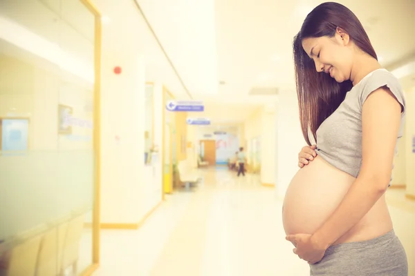 Gravid kvinna kommer till doktorn på sjukhuset. Vintage färg — Stockfoto