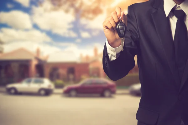 Businessman showing a car key - car sale & rental business conce — Stock Photo, Image