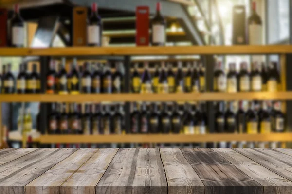 Wood table and wine Liquor bottle on shelf Blurred background ca — Stock Photo, Image