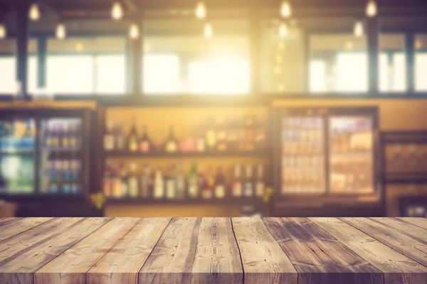 Wood bar top on blur colorful alcohol drink bottle background.Vi
