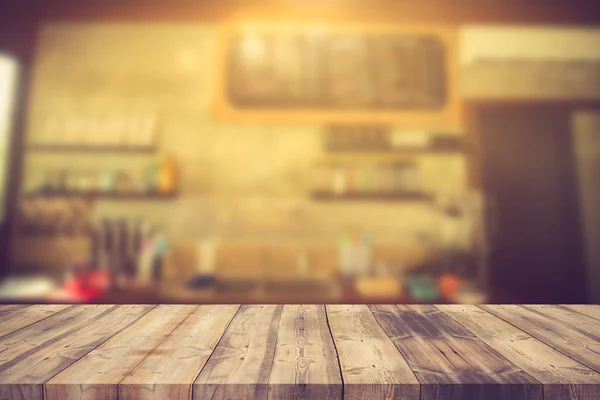 Wood table top on blur background of coffee shop (or restaurant) — Stock Photo, Image