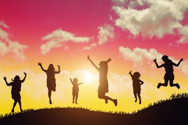 Grup Hipster gençler Jumping of gün batımında silüeti