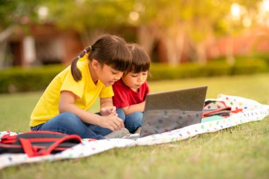 Two asian child girl students study online with teacher by video call together. 