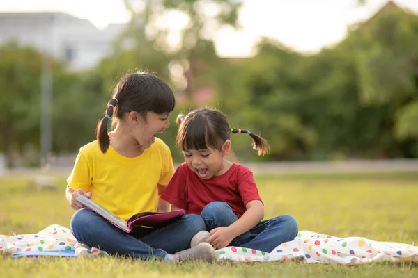 Two Beautiful Little Girls Reading Books Garden Sitting Grass Concept — Zdjęcie stockowe