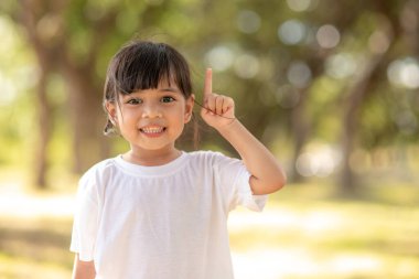 Asian Little Girl smiling and pointing up with the finger