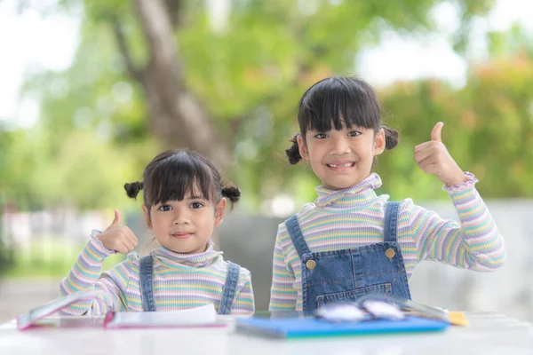 Dwie Studentki Małe Azjatki Czytające Książkę Stole — Zdjęcie stockowe