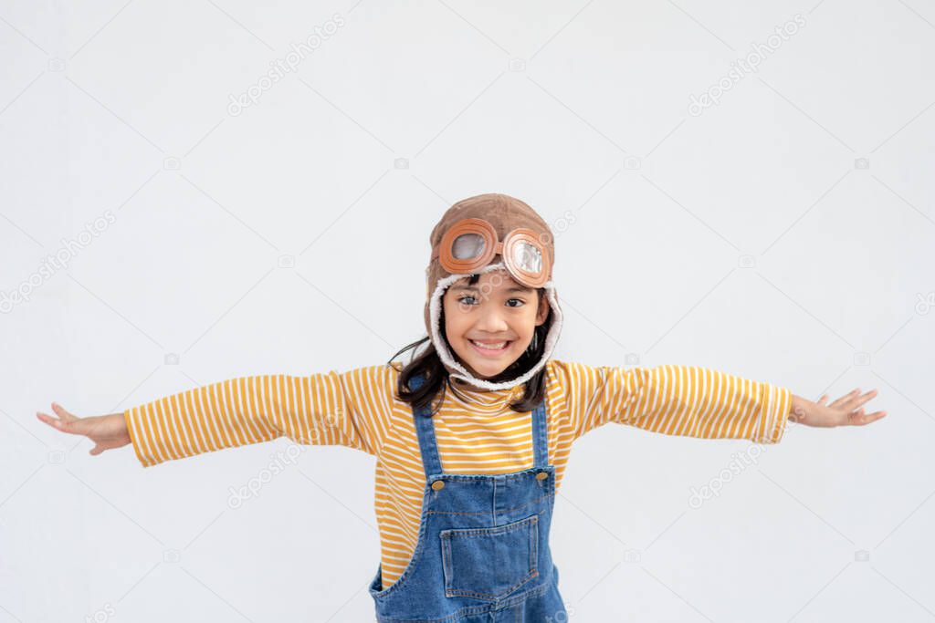 A little child girl in an astronaut costume is playing and dreaming of becoming a spaceman. on white background