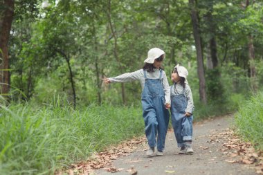 Çocuklar ormandaki aile kamp alanına gidiyorlar. Turist yolu boyunca yürüyün. Kamp yolu. Aile seyahati konsepti.
