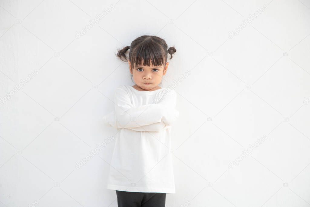 Angry little girl over white background, sign and gesture concept