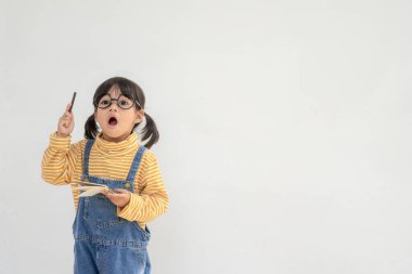Okula dönelim. Beyaz arka planda gözlüklü komik küçük bir kız. İlkokuldan elinde kitap olan bir çocuk. Eğitim