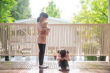 İki küçük kız ayı için kavga ediyor.