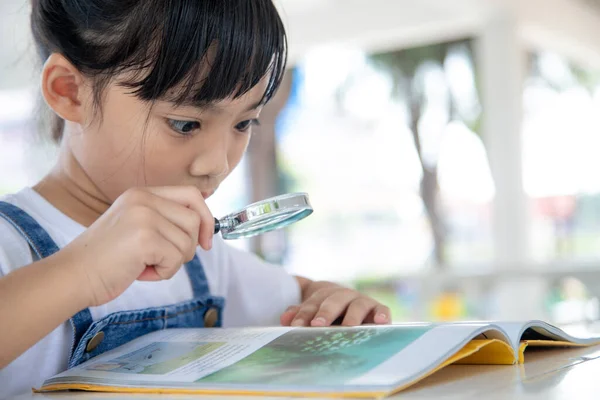 Menina Asiática Lendo Livros Mesa Com Uma Lupa — Fotografia de Stock