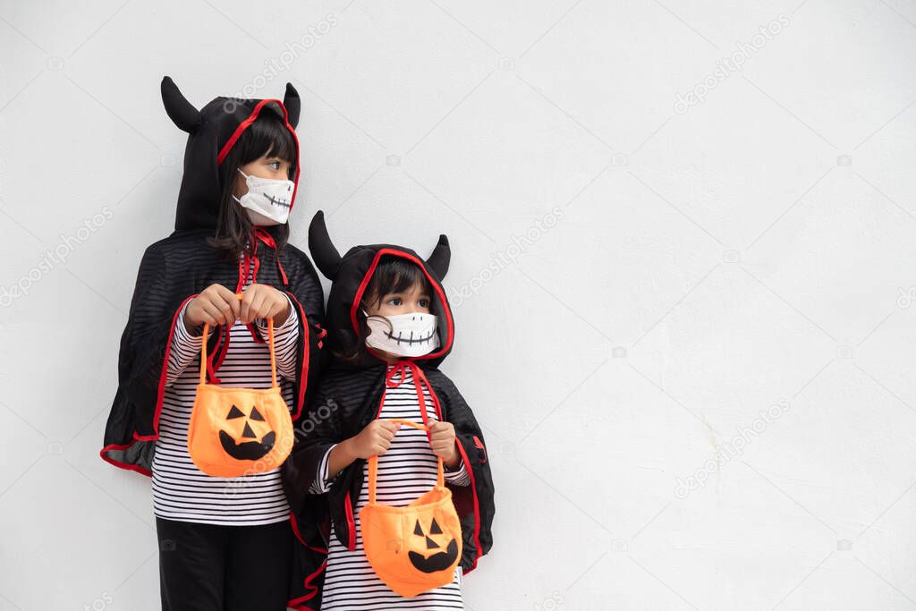 Happy sibling girls at the halloween party. children wearing costumes halloweens. concept of children ready for a party. 