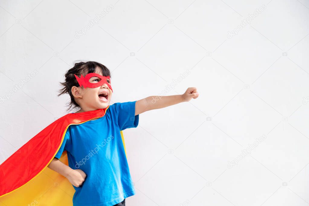 Little child girl plays superhero. Child on the white background. Girl power concept
