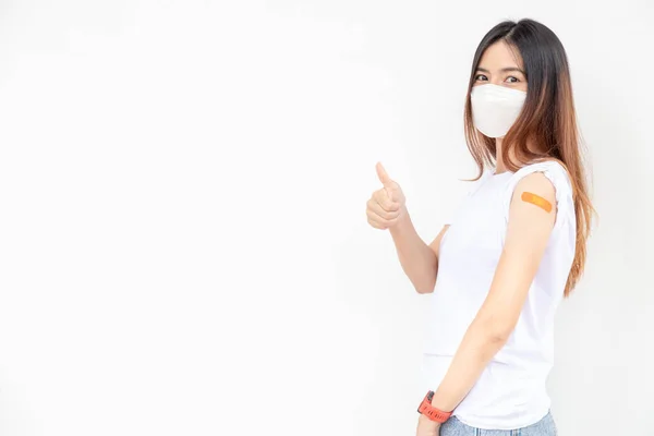 アジアの女性は腕に包帯を表示します 白い背景でワクチンを受け取った後 幸せなアジアの女性は良い感じます 親指アップ — ストック写真