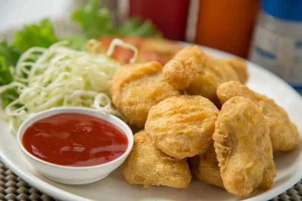 Een stapel van kipnuggets op wit bord met saus — Stockfoto