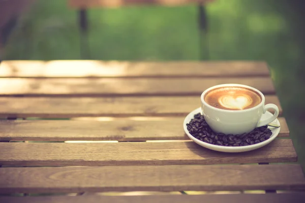 Latte Art kaffe med kaffebönor vintage färg — Stockfoto