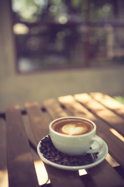 Latte Art kaffe med kaffebönor vintage färg — Stockfoto