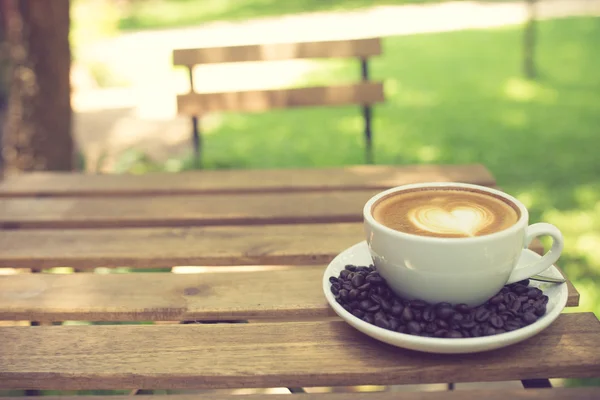 Latte Art kaffe med kaffebönor vintage färg — Stockfoto