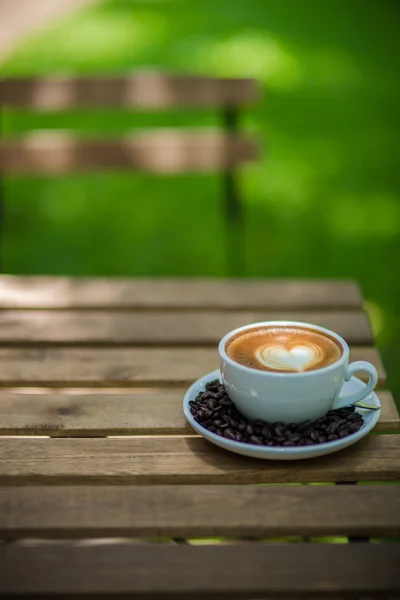 Latte Art kaffe med kaffebönor — Stockfoto