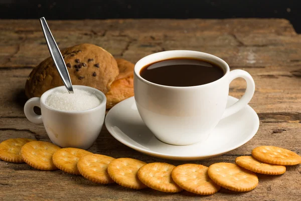 Xícara de café em uma placa de madeira e biscoitos — Fotografia de Stock