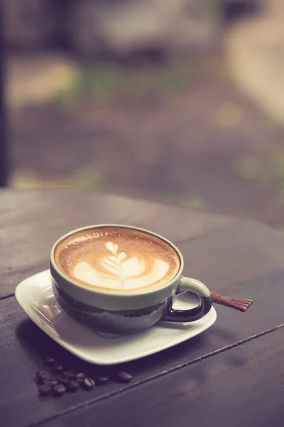 Latte Art kaffe med kaffebönor vintage färg — Stockfoto