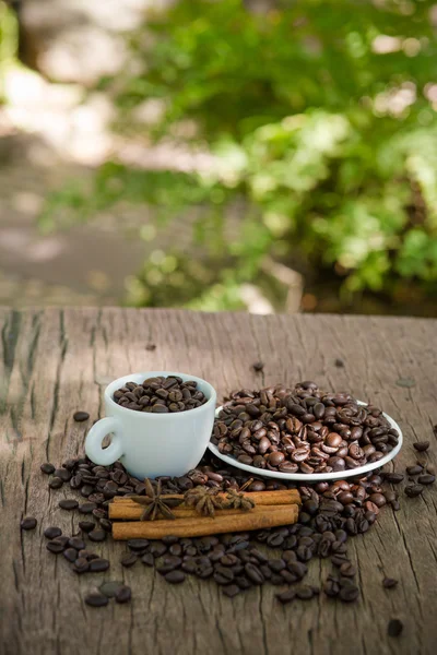 Tasse à café et grains de café sur une table en bois — Photo