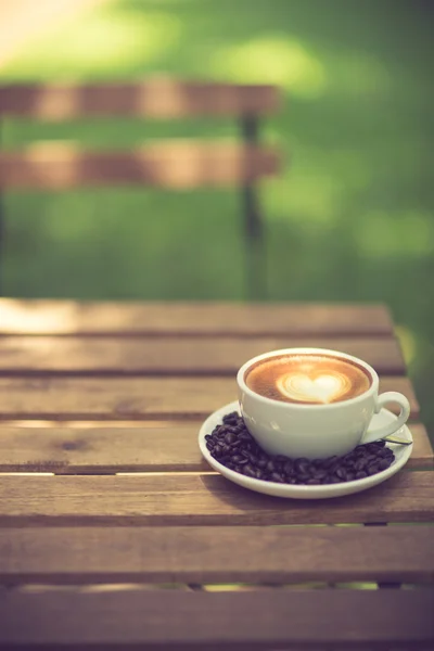 Latte Art kaffe med kaffebönor vintage färg — Stockfoto