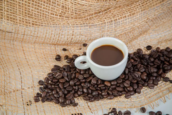 Tasse de café et haricots sur un fond blanc. — Photo