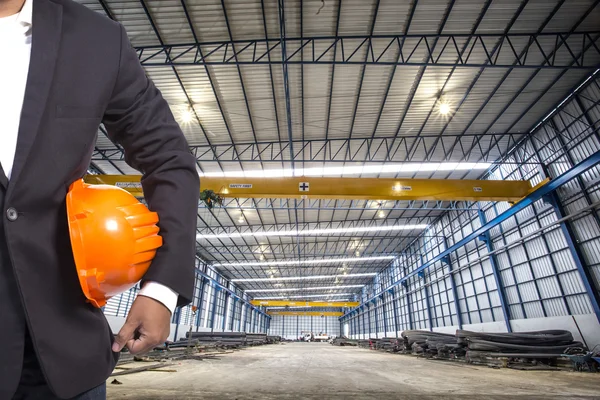 Inženýr drží oranžová helma pro bezpečnost pracovníků v továrně b — Stock fotografie