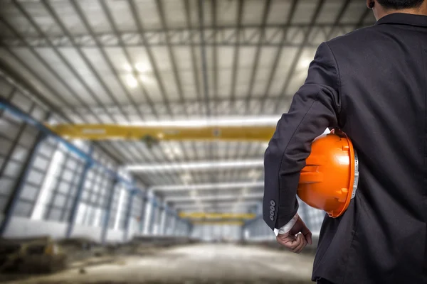 işçi güvenliği için turuncu kask fabrika b üzerinde tutan mühendisi