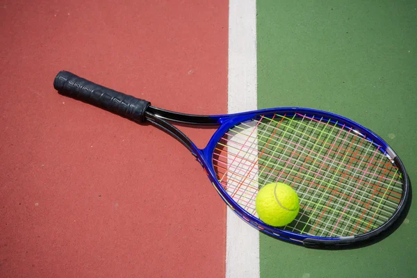 Tennisracket och bollar på tennisbanan — Stockfoto