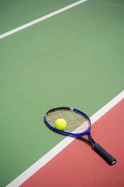 Rakieta tenisowa i piłki na korcie tenisowym — Zdjęcie stockowe