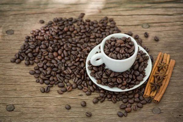 Tasse à café et grains de café sur une table en bois — Photo