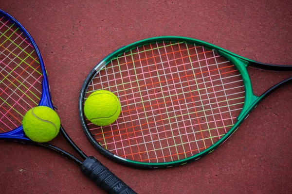 Tennisracket och bollar på tennisbanan — Stockfoto