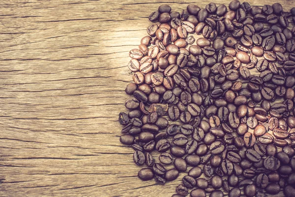 Coffee beans on wood background vintage color — Stock Photo, Image
