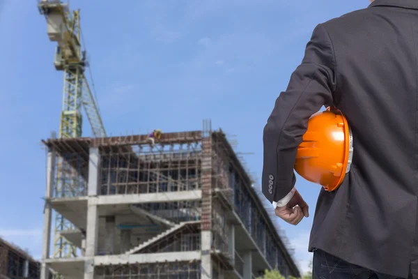 Inženýr drží oranžová helma pro bezpečnost pracovníků na contructi — Stock fotografie