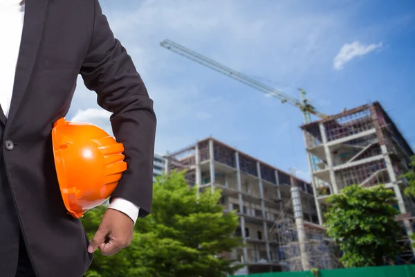 Ingeniero sosteniendo casco naranja para la seguridad de los trabajadores en contructi —  Fotos de Stock