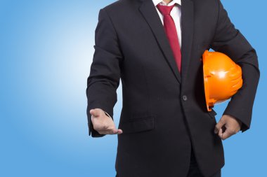 işçi güvenliği için turuncu kask mavi sırt üstü tutan mühendisi