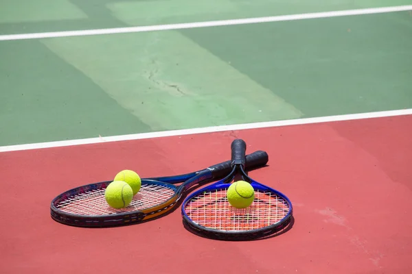 Rakieta tenisowa i piłki na korcie tenisowym — Zdjęcie stockowe