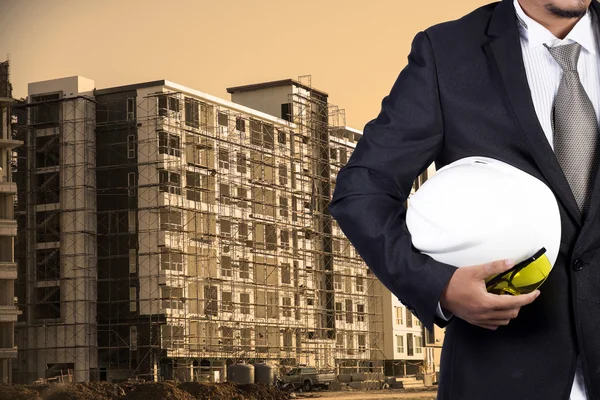 Ingeniero sosteniendo casco blanco para la seguridad de los trabajadores en contructio — Foto de Stock