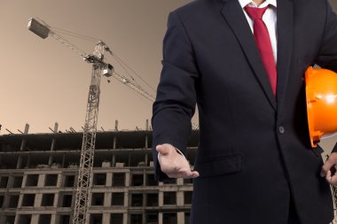 işçi güvenliği için turuncu kask contructi üzerinde tutan mühendisi