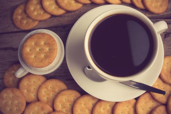 Taza de café en una tabla de madera y galletas — Foto de Stock