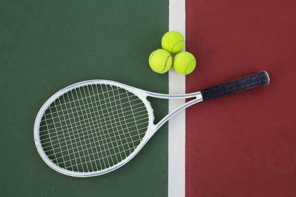 Tennisracket och bollar på tennisbanan — Stockfoto