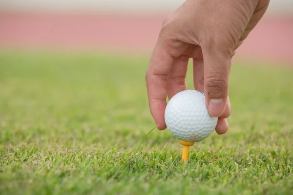 Hand halten Golfball mit Abschlag auf dem Platz, Nahaufnahme — Stockfoto