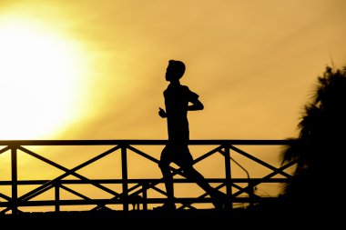 Köprü ve günbatımı üzerinde çalışan siluet