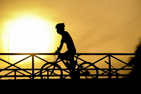 Silueta del motorista en puente y puesta de sol — Foto de Stock